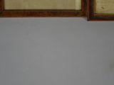 two framed pictures on the wall of a room