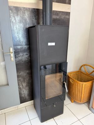 a black stove in the corner of a room with a basket on the floor