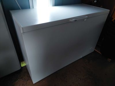 un congélateur coffre blanc dans un coin de la pièce