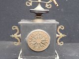 a clock with a bird on top of it on a table