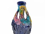 a blue vase with a multicolored design sitting on a white surface