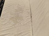 a bed with a white sheet with a hole in the middle of it