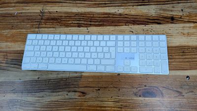 a white keyboard sitting on top of a wooden table