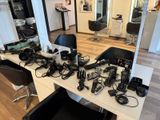 de nombreux sèche-cheveux posés sur une table dans un salon de coiffure
