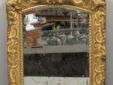 an image of a gold framed mirror sitting on top of a white table
