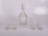 quatre verres et une carafe posés sur une table