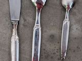 three forks, a knife, and a spoon on a table
