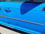 a blue car parked in a parking lot with its door open