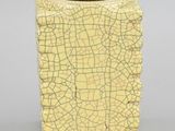 a yellow vase with a cracky surface on it