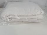 a stack of white pillows sitting on a white bed