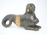bronze statue of a woman laying down on a white surface