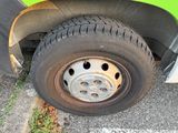a close up of a tire on the side of a green truck