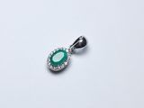 une image représentant un pendentif orné d'une pierre verte entourée de diamants