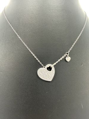 a necklace with a heart and a key on a mannequin mannequin