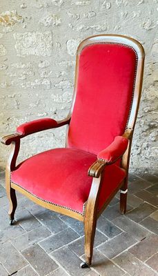 une chaise rouge posée devant un mur de briques
