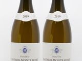 two bottles of white wine sitting next to each other on a white surface