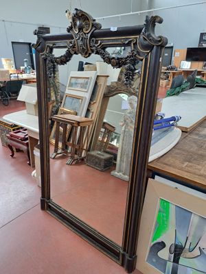 a large mirror in the middle of a room with pictures on the wall