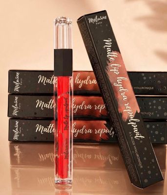 trois gloss sont posés sur une pile de livres