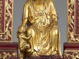 une statue en or représentant une personne assise sur une table
