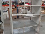 a white shelf in the middle of a warehouse