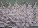 de nombreux brassières blanches accrochées les unes à côté des autres sur un mur