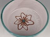 a white bowl with a brown flower on it
