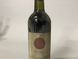 une vieille bouteille de vin posée sur une table blanche