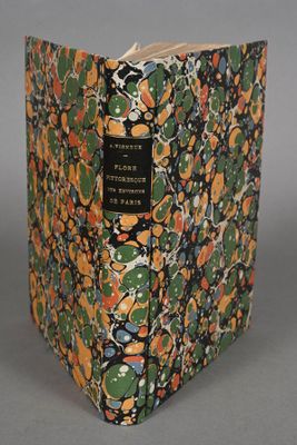 an old book with a floral design on it sitting on a table