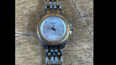un gros plan d'une montre-bracelet posée sur une surface en bois