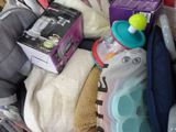 a pile of baby items in a basket with a baby bottle