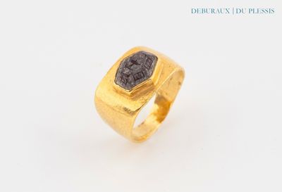 an image of a gold ring with a black stone in the center