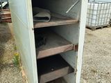 an old metal cabinet that is outside in the dirt