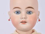 a close up of a doll with blue eyes on a white background