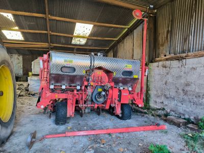 un tracteur garé dans une grange, avec un réservoir fixé dessus