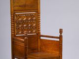 une chaise en bois dont l'assise est sculptée, sur fond blanc
