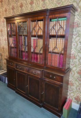 une bibliothèque remplie de livres, placée dans un coin de la pièce