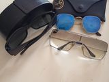 une paire de lunettes de soleil et un étui à lunettes posés sur une table à côté d'une paire de lunettes de vue