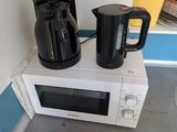 un micro-ondes et une cafetière posés sur le micro-ondes