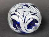 a blue and white marble on a black surface