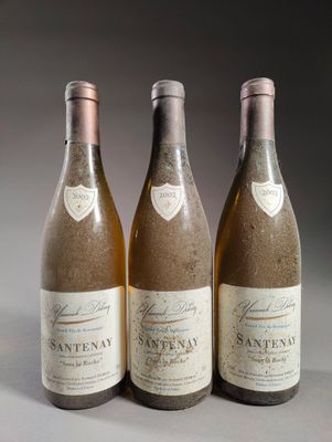 trois bouteilles de vin posées sur une table, l'une à côté de l'autre