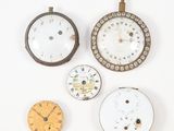 Plusieurs types d'horloges sont exposés sur un fond blanc