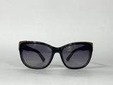 lunettes de soleil noires de style « œil de chat » avec des détails dorés sur fond blanc