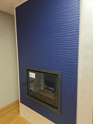 une cheminée dans un coin d'une pièce dont le mur est bleu