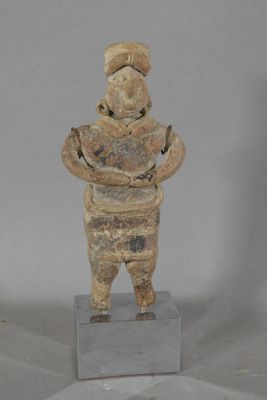 statue of a man with a hat on his head standing on a block