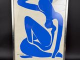 un tableau bleu et blanc représentant une femme assise sur une chaise