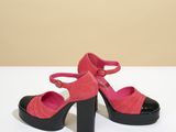 pink and black high heeled shoes on a white surface