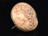 une broche ancienne en ivoire sculpté, ornée d'une tête de femme