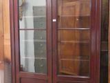 un grand meuble en bois avec des portes en verre dans une pièce