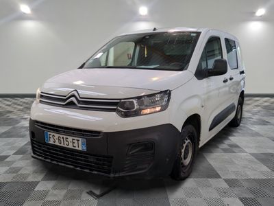 la camionnette blanche est garée dans une grande pièce au sol en damier