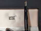 a black pen and a black and gold pen in a box